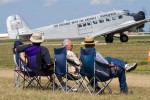 Four long-time Oshkosh attendees wait for the visiting Junkers JU-52 (HB-HOT) to clear the runway and begins its demo.